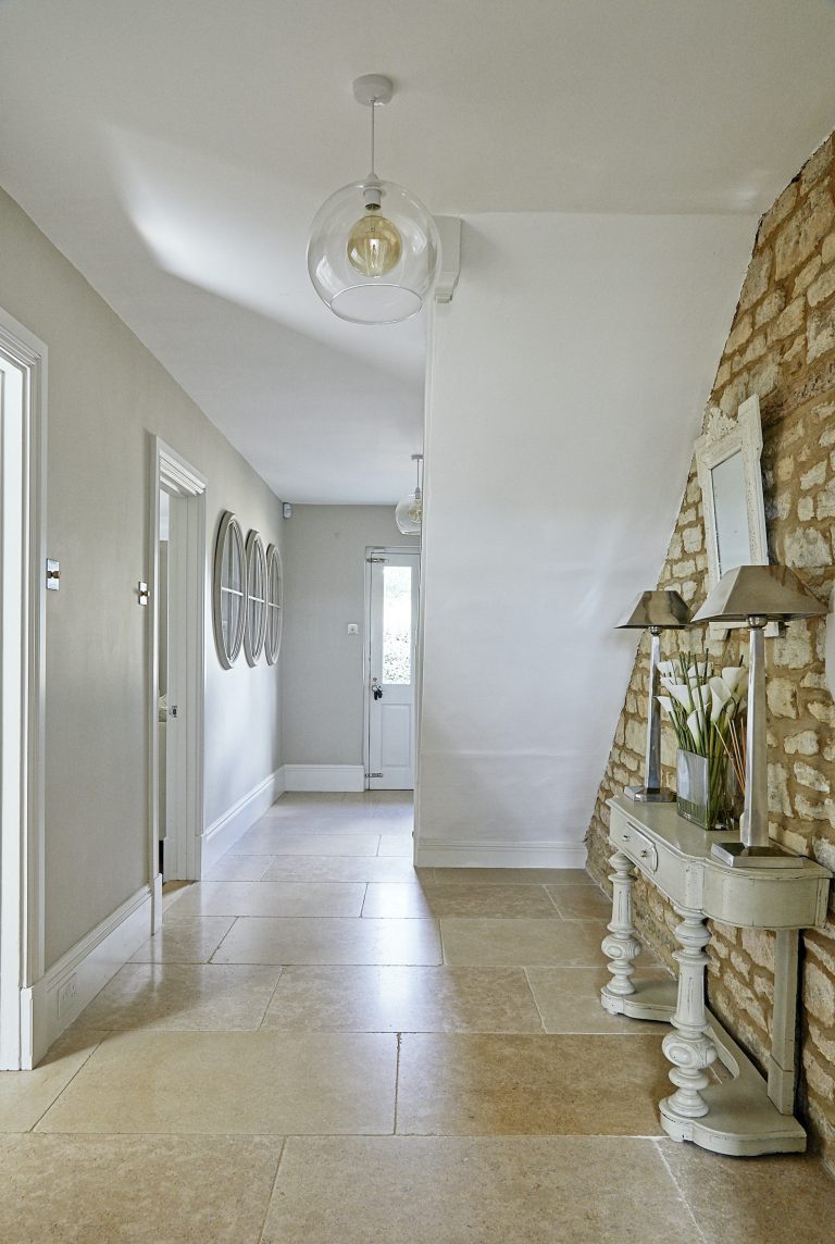 Wisteria house entrance hall with stone floor and exposed stone wall