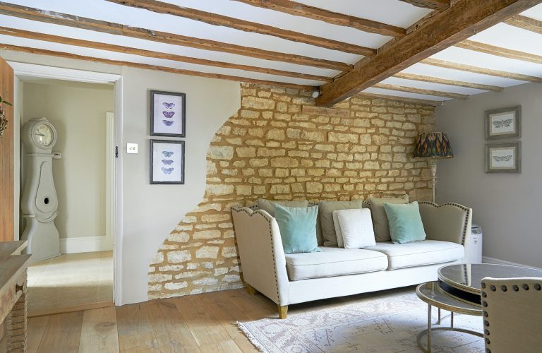 Wisteria House reception two with exposed stone wall and wood floor.