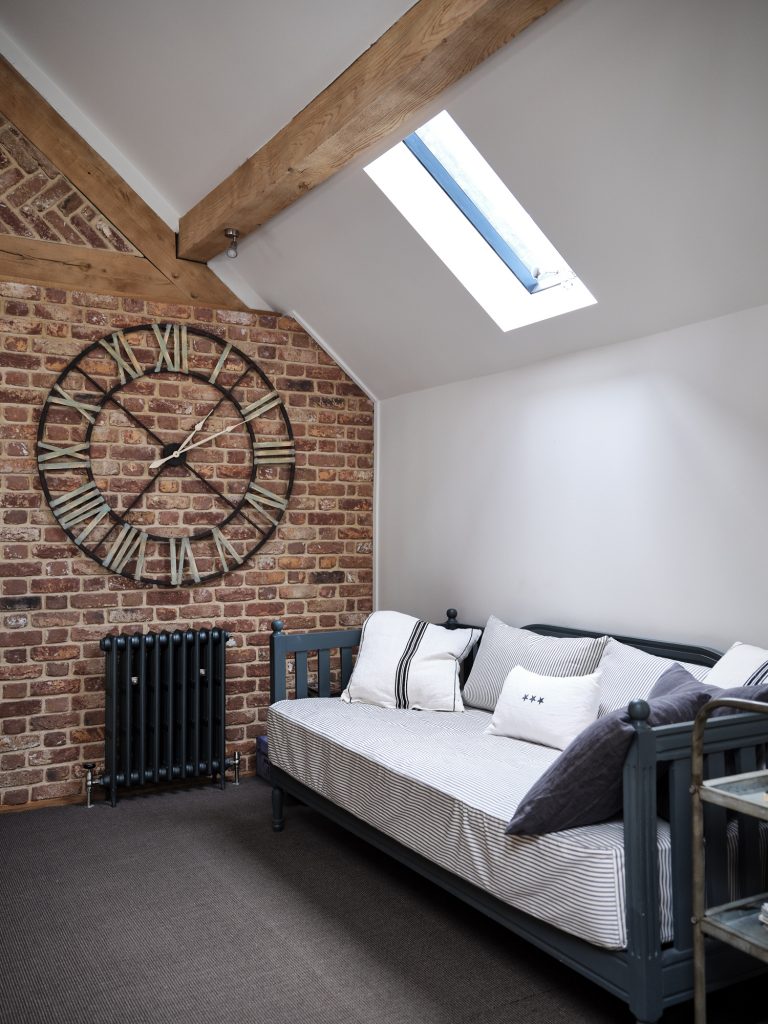 SITTING AREA WITH EXPOED BRICK WAL AND LARGE WALL MOUNTED CLOCK FACE -HAGUE BARN HENLEY ON THAMES, RG9 - SHOOTFACTORY - OTHER UK LOCATION HOUSE